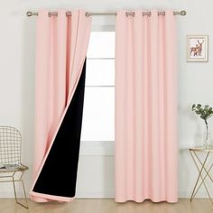 a pink curtain with black side panels in front of a white wall and a chair