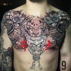 a man with tattoos on his chest is wearing a dragon and flower tattoo design in front of him