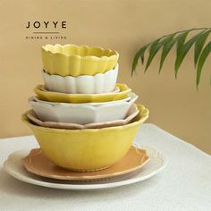 four yellow and white dishes stacked on top of each other