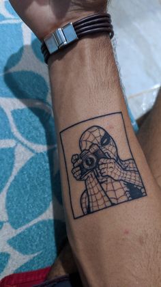 a man's arm with a tattoo on it that has an image of a spider - man