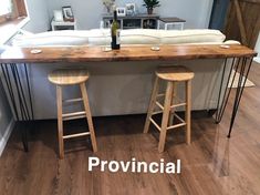 two stools are sitting at the bar in this living room with wood flooring