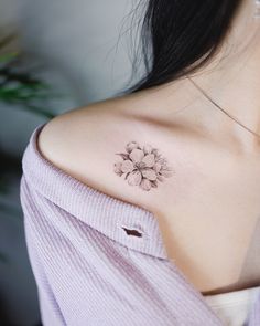 a woman with a flower tattoo on her shoulder