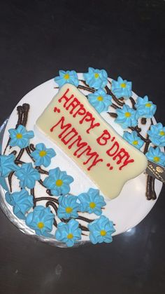 a birthday cake decorated with blue flowers and a sign