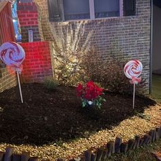 some lollipops are sitting in the middle of a garden with flowers and grass