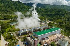 an aerial view of a factory with steam rising from it