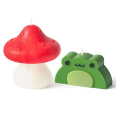 a candle with a mushroom on it next to a green toad