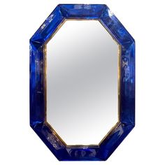 a blue glass mirror sitting on top of a white wall