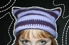 a doll wearing a knitted cat hat