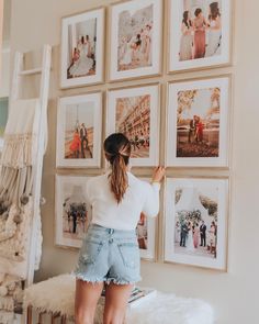 a woman standing in front of pictures on the wall