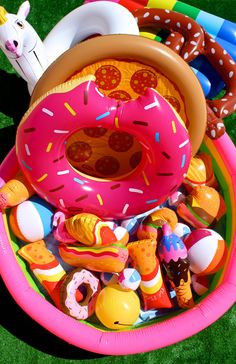 an inflatable donut surrounded by toys on the grass with fake doughnuts