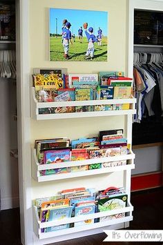 a book shelf filled with children's books in a room next to a closet