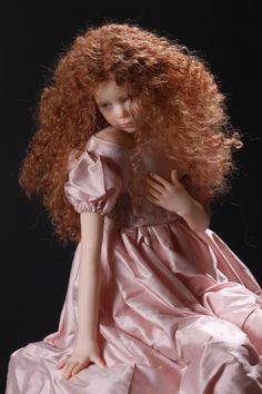 a doll with red hair wearing a pink dress