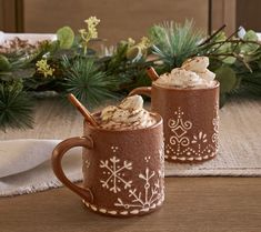 two mugs filled with hot chocolate and whipped cream