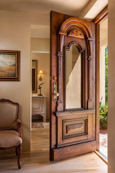 an ornate wooden door with mirror on the front and side panels, in a living room