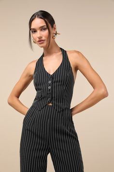 From the office to the after-work drink, the Lulus Pur-Suit of Chic Black and White Pinstripe Vest Top is the elevated look you need to beat the midweek blues! Midweight woven fabric shapes this on-trend top that has a V-neckline, an open halter-style back, and a functional button placket at the front. Decorative mini pocket adds a fun touch, and a smocked panel at back creates a perfect fit! Angled hems. Pair with the matching pants for a complete look! Fit: This garment fits true to size. Length: Size medium measures 17.5" from top to bottom. Bust: Great for any cup size. Waist: Fitted - elastic waist allows stretch. Undergarments: May be worn with a strapless bra, adhesive bra, petals, or no bra. Fabric: Fabric has no stretch. Lined. Shell: 91% Polyester, 9% Rayon. Lining: 97% Polyester Chic Striped Notch Lapel Suit, Chic Striped Suits With Notch Lapel, Chic Striped Suits For Office, Chic Pinstripe Suits With Notch Lapel, Chic Pinstripe Suits For Office, Spring Striped Fitted Suit, Spring Fitted Pinstripe Suits, Spring Pinstripe Fitted Suit, Pinstripe Vest