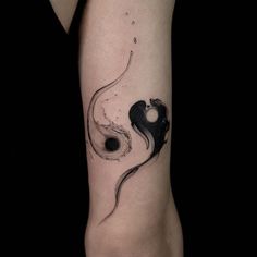 a woman's arm with a black and white tattoo design on the left forearm