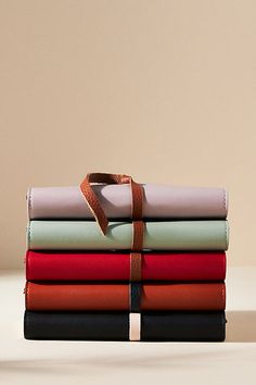 a stack of folded sheets with a brown ribbon tied to it's end on a table