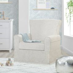 a baby's room with blue and white wallpaper, a rocking chair and dresser