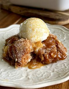 a white plate topped with an ice cream and apple cobbler covered in powdered sugar