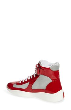 Prada creates a high-top version of its cult sneaker, which was originally designed for the Luna Rossa sailing team to wear during the 2000 America's Cup. It's crafted from a mix of patent leather and breathable mesh with a lightweight, flexible sole sporting the iconic red logo. 5" shaft, 12" circumference (size 7.5) Lace-up style; adjustable ankle strap with hook-and-loop closure Removable insole Textile and leather upper and lining/rubber sole Made in Italy Men's Designer Shoes Classic Red Luxury High-top Sneakers, Luxury Red High-top Sneakers For Sports, Luxury Red High-top Sneakers, Red Designer High-top Sneakers For Streetwear, Luxury Fade-resistant Red Sneakers, Americas Cup, Mens Designer Shoes, Red Logo, Up Styles