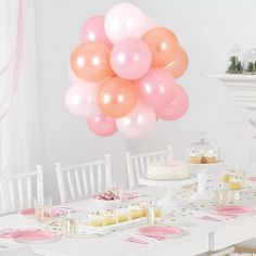 a table topped with lots of pink and white balloons next to a cake on top of a plate