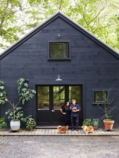 two people standing in front of a black house