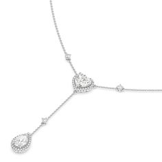 Inspired by a lariat necklace, this piece has a Y-shaped silhouette and two sparkling pendants. The chain necklace holds a heart pendant dotted at the center with a heart-cut diamond framed by a heart-shaped halo of petite round diamonds. Gently dropping from the heart pendant is a pear-cut diamond haloed by round diamonds. This necklace is a piece of everyday fine jewelry that can effortlessly enhance your daily wardrobe.