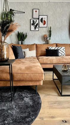 a living room filled with lots of furniture next to a wall covered in pictures and plants