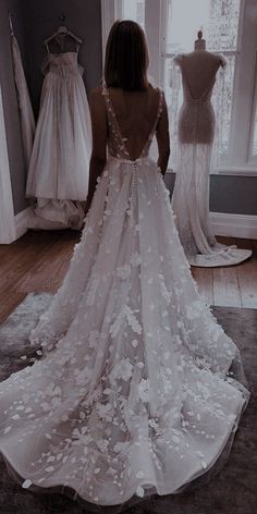 the back of a woman's wedding dress with flowers on it