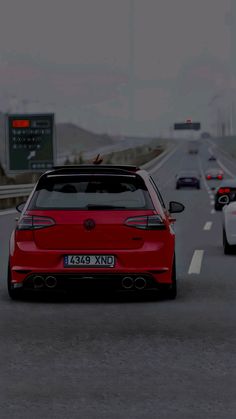 two cars are driving down the highway in front of another car on the other side