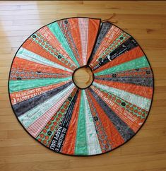 an orange, green and black piece of cloth on a wooden floor