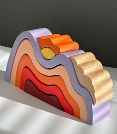 a stack of colorful wooden blocks sitting on top of a white table