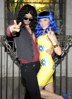 a man and woman dressed in costumes posing for the camera with one hand up to the camera