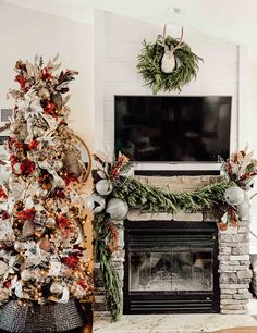 a living room decorated for christmas with a fire place and tv above the mantel