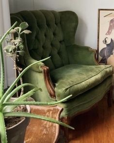 a green chair sitting next to a potted plant