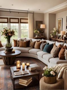 a living room filled with lots of furniture and pillows on top of a rug next to a window