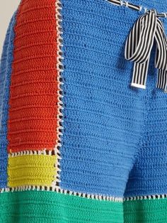 a close up of a person's shorts with a bow on the side and multicolored crochet