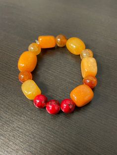 Orange and Red Glass Bead Stretch Cord Bracelet Orange Stretch Bracelet With Large Beads As Gift, Gift Orange Stretch Bracelet With Large Beads, Casual Orange Jewelry With Large Beads, Red Spiritual Stretch Bracelet With Colorful Beads, Casual Red Hand-strung Bracelets, Adjustable Red Gemstone Beads Stretch Bracelet, Casual Red Hand-strung Jewelry, Casual Red Round Stretch Bracelet, Casual Red Stretch Bracelet With Colorful Beads