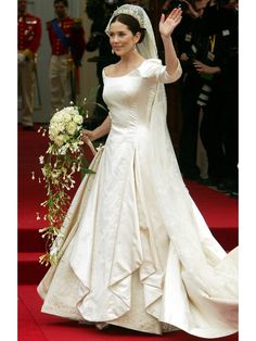 the bride waves to her guests as she walks down the aisle in her wedding dress