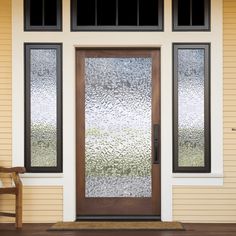 a wooden chair sitting in front of a door with frosted glass on the side