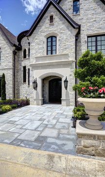 a large stone house with landscaping around it