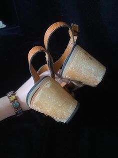 Very funky 1950's brown leather sandals with wooden cut out wedge heels. Bottoms are a soft black material, one shoe is missing a chunk of the soft bottom by the heel, shown in photo. I have not repaired. Wood heels have some scratches. Being sold as is Women's size 5 Retro Leather Open Toe Sandals, Retro Brown Leather Sandals, Vintage Leather Sandals With Round Toe, Retro Open Toe Clogs For Summer, Vintage Brown Sandals With Round Toe, Retro Leather Sandals With Block Heel, Vintage Closed Toe Platform Sandals, Retro Brown Platform Sandals, Wedge Sandals With Wooden Block Heel