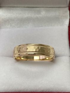 a yellow gold wedding band in a box