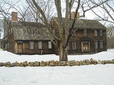 an old log house in the winter with snow on the ground