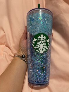 a person holding a starbucks cup filled with glitter