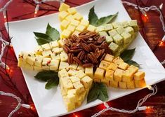 a white plate topped with pieces of cheese and nuts