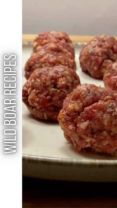 some meatballs are on a white plate and ready to be cooked in the oven