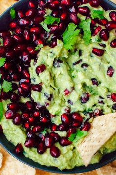 a bowl filled with guacamole and garnished with pomegranates