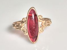 Very pretty antique ruby navette ring from the Victorian era in 10K yellow gold. This lovely ring features a marquise-cut cabochon ruby in a classic late Victorian oval bezel mount. The ruby is a simulated ruby, typical of the era, and measures 16.4x6mm and appears to be original to the ring with no chips or cracks and only very minimal age related wear. Beautiful. classic late Victorian-Art Nouveau detail to the sides. The shank is a beautiful handmade double shank and is solid all around. Ring Navette Ring, Antique Ruby Ring, Cabochon Ruby, Antique Collectors, Victorian Rings, Victorian Art, Lovely Ring, Fantasy Jewelry, Ruby Ring