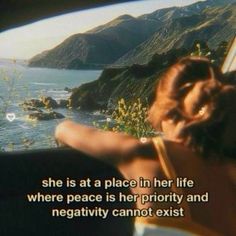 a woman sitting in a car looking out at the ocean